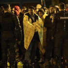 Un grupo de foráneos esperan un autobús para su traslado durante una operación de desalojo de campamentos de migrantes en París.-JULIEN DE ROSA (EFE)