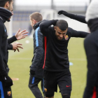 Los jugadores del Barça saludan a Rafinha, en su regreso a los entrenamientos.-EL PERIÓDICO