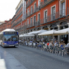 Un autobús circula por la Plaza Mayor junto al público sentado en las terrazas.-J. M. LOSTAU