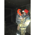 Un bombero rescata a un menor del bloque tras el incendio.-E. M.