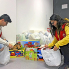 Dos voluntarios de Cruz Roja distribuyen juguetes en distintos lotes antes de proceder a la entrega.-E. M.