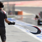 Un mecánico de Sauber espera a su monoplaza en la calle de boxes con la piruleta en sus manos.-JOSÉ MARÍA RUBIO