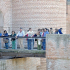 Un grupo de turistas, acompañados por un guía, se asoma a la pasarela del Castillo de La Mota, para observar el foso-SANTIAGO G. DEL CAMPO