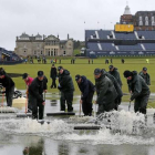 Operarios de Saint Andrews achican aguas para intentar que se reanude la jornada en el Abierto Británico.-Foto: AFP / ADRIAN DENNIS