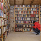Las hileras de libros se extienden en la estanterías de la antigua pobrera y viejo potro del pueblo rehabilitado en el año 2006. -SANTI OTERO