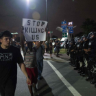 Manifestantes pasean con pancartas ante el cordón policial, esta madrugada en Charlotte.-AFP / NICHOLAS KAMM