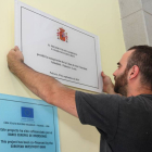 Un operario coloca la placa conmemorativa de la inauguración de la línea de Alta Velocidad en la estación de Palencia, con el nombre de Palencia corregido.-ICAL