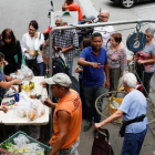 Venezolanos hacen cola para pagar la fruta y las verduras en un mercado callejero, en Caracas, el 13 de noviembre.-REUTERS / MARCO BELLO