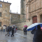 Varios ciudadanos salmantinos se protegen de la lluvia.-ICAL