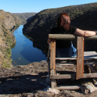 Una mujer disfruta del paisaje del Arribe del Duero sentada en el banco El Hullón.  A la d. indicador  colocado en el  camino.-J.L.C.