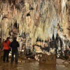 Dos visitantes contemplan la majestuosidad de las estalactitas y estalagmitas en una de las siete salas visitables que conforman el recorrido de las Cuevas de Valporquero.-ANXO RIAL