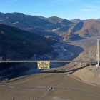 Viaducto del pantano de Barrios de Luna con la pancarta colocada ayer por Greenpeace para denunciar la mala gestión del agua.-E.M.