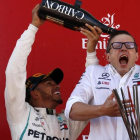 Lewis Hamilton ducha en champaña a Peter Bonnington, uno de sus ingenieros en el equipo Mercedes. /-AP / MANU FERNÁNDEZ