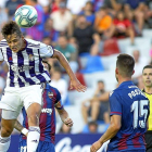 El delantero blanquivioleta Ünal remata de cabeza ante la mirada del central levantinista Postigo.-PHOTO-DEPORTE