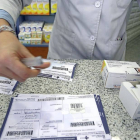 Una farmacéutica recorta el identificador del medicamento para pegarlo en la tradicional receta de papael.-Ical