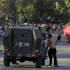 Un manifestante se enfrenta a un vehículo militar durante las protestas en Chile.-AP
