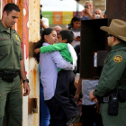 Un hombre abraza a un niño en la frontera con México en California, el pasado 19 de noviembre.-REUTERS / MIKE BLAKE