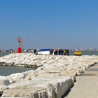 Bomberos y miembros de los servicios de rescate trabajan junto al casco de un barco tras su naufragio en Rimini.-EFE