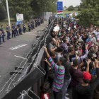 Refugiados sirios ante la valla fronteriza de Hungría.-MARKO DJURICA / REUTERS