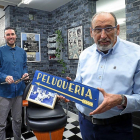 Fran junto a Paco Moreno, que sujeta el cartel de la peluquería de su abuelo, Don Francisco.-MIGUEL ÁNGEL SANTOS / PHOTOGENIC