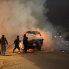 Bomberos egipcios apagan el fuego de varios vehículos que han sido quemados durante los disturbios de este domingo.-Foto: AFP
