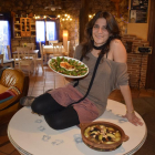 Nayara, en el interior del comedor, con una ensalada del Tiétar con higos y el ‘tayín’ de cordero sobre la mesa.-ARGICOMUNICACIÓN