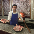 Roberto Cristóbal posa con un lechazo a punto de meterlo en el horno.-
