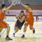 Un jugador del Ciudad de Valladolid intenta esquivar a dos rivales.-J. M. LOSTA