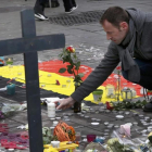 Un hombre deja flores en el tributo a las víctimas de los atentados de Bruselas-FRANCOIS LENOIR