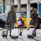 Unos turistas se dirigen a una parada de taxis en Barcelona.-FERRAN NADEU