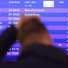Un hombre ante la información de vuelos cancelados.-ARNE DEDERT (AFP)