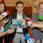 El portavoz del PSOE sostiene una foto del ex subdelegado del Gobierno en la que aparece durante una campaña de seguridad vial.-J.M. Lostau