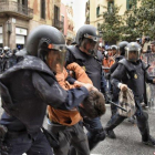 Dos policías con uno de los manifestantes detenidos en Vía Laietana.-MANU MITRU