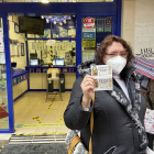 Los más rezagados ultiman la compra de sus décimos para el sorteo del 22 de diciembre, esta mujer lo hace en la administración de lotería de la calle Mantería, en el centro de Valladolid.- J.M. LOSTAU