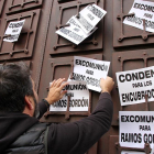 Un manifestante coloca carteles pidiendo la excomunión de RamosGordón y la condena para los encubridores en Astorga.-ICAL