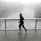 Un hombre corre sobre un puente lleno de cencellada.-ICAL