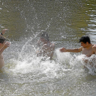 Jóvenes refrescándose durante la ola de calor en la Playa de las Moreras de Valladolid-J.M. LOSTAU