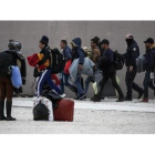 La policía griega escolta a inmigrantes en el exterior de un estadio en el sur de Atenas.-AP / YORGOS KARAHALIS.