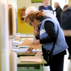 Una mujer escoge las papeletas para ejercer su derecho al voto.-ICAL