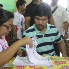El boxeador Emmanuel Manny "Pacman" Pacquiao (d) ejerce su derecho al voto en Kiam.-KIM TIBLANI / EFE