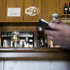 Un vecino intenta conectarse a la WiFi gratuita de un bar de un municipio.-EL MUNDO