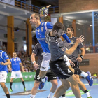 El central Adrián Fernández a punto de lanzar tras chocar con el defensor rival Marc Canyigueral.-PHOTO-DEPORTE