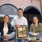 Sara, Santi y Macarena posan en el patio del restaurante con una fotografía tomada en el mismo lugar años atrás y dos de los platos de su carta-
