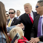 Trump (centro) saluda a varios ciudadanos a su llegada al aeropuerto internacional de Saint Louis, el 29 de noviembre.-AP / ANDREW HARNIK