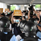 Un grupo de manifestantes sostienen pancartas de protesta contra la policía hongkonesa, este jueves.-EDWIN KWOK (EFE)