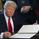 Donald Trump firma una orden ejecutiva en el Despacho Oval, este viernes.-