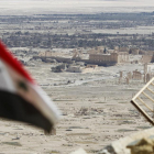 Una bandera siria ondea ante las ruinas de la histórica ciudad de Palmira.-REUTERS / OMAR SANADIKI