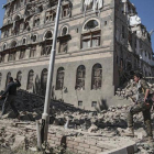 Dos rebeldes yemeníes inspeccionan las ruinas de edificios destruidos por los bombardeos en Saná.-HANI MOHAMMED (AP)