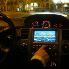 Un conductor manipula el GPS integrado en su vehículo.-JULIO CARBÓ