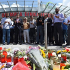 Varias personas rezan en el memorial de velas y flores, colocada frente al centro comercial Olympia, en Munich, este domingo.-AFP / CHRISTOF STACHE
